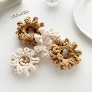 Close-up of soft plush scrunchies in cream and light brown for autumn hairstyle