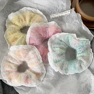 Detail of plush lace hair scrunchies with pearls in assorted soft pastel colors
