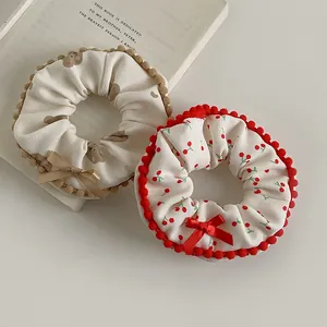 Detail of plush scrunchies featuring bear and cherry patterns with ribbon bows