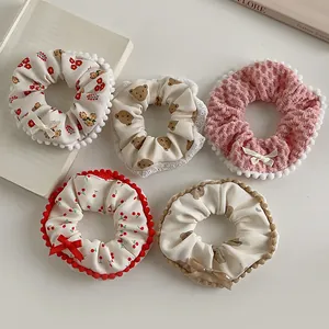 Detail view of five different plush scrunchies with cute bear and floral patterns