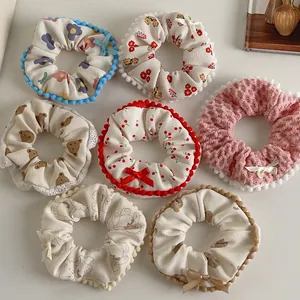 Detailed flat lay of plush hair scrunchies with lace edges and cute cartoon bear prints