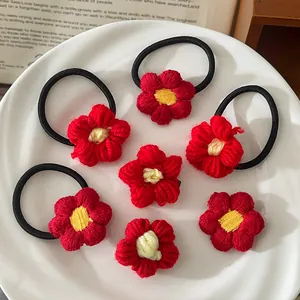 Gros plan sur les élastiques à fleurs rouges au crochet avec textures tricotées