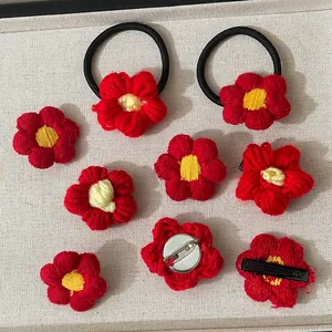 Détail de fleurs rouges au crochet faites main avec élastiques, pinces et broches mignonnes