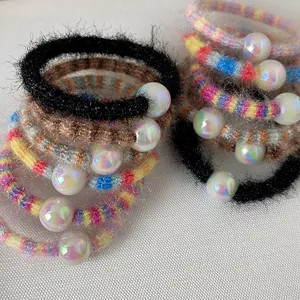 Gros plan d'élastiques à cheveux arc-en-ciel avec perles et texture en peluche