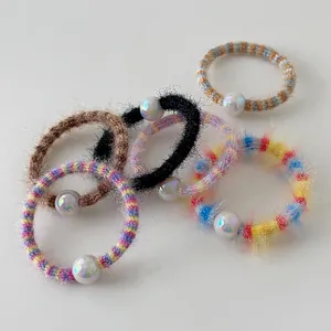 Vue macro de cinq chouchous en peluche colorés avec des détails de perles irisées