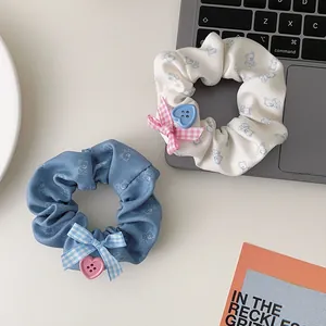 Détail de chouchous en tissu avec motifs d'ours, nœuds à carreaux et boutons cœur