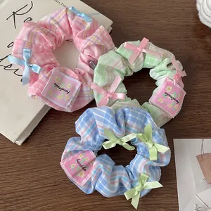 Three-piece set of plaid scrunchies with bow knots in pink, blue, and green colors
