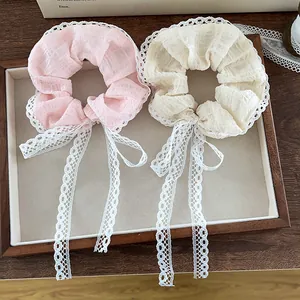 Elegant lace scrunchies set with bow ribbons in pink and cream on a wooden tray