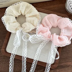 Detail of lace-edged scrunchies with long ribbons on a rustic wooden tray setup