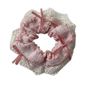 Roze haarelastiekje met kanten rand en strikjes op een schone witte achtergrond