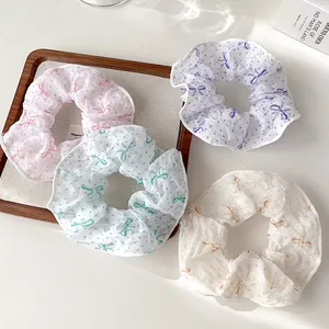 Detailansicht von Haargummis aus Organza mit Falten, Punkten und Schleifenmuster