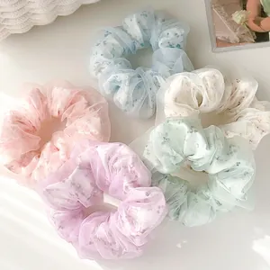 Dettaglio di cinque elastici in organza floreale in colori pastello con ombre eleganti
