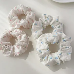 Floral print hair scrunchies set in soft pastel pink and blue cotton fabric on white