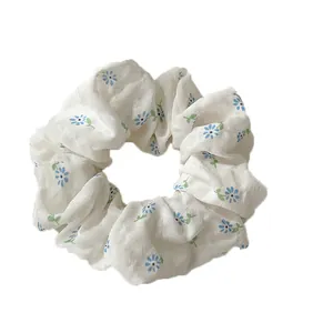 Floral print scrunchie in off-white fabric with blue flower patterns for women