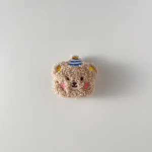 Détail d'un ours en peluche marron avec chapeau de fête et broderie pour accessoires DIY