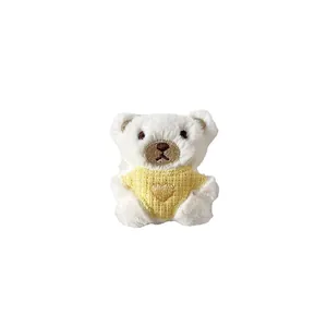 Simpatico orsetto di peluche bianco con maglione giallo a maglia e cuore
