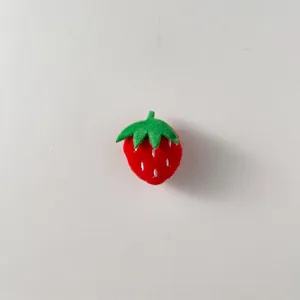 Simpatico accessorio fragola in peluche con foglie verdi e semi ricamati bianchi