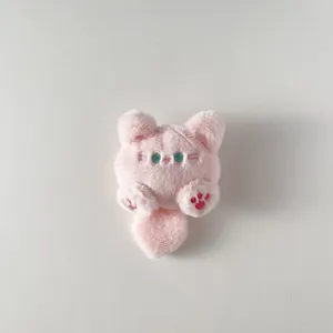 Portachiavi gatto di peluche rosa con zampe ricamate e occhi verdi su fondo bianco