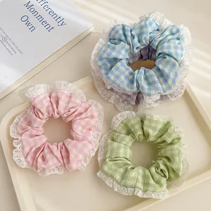 Gros plan de chouchous à carreaux avec bordure en dentelle rose, bleue et verte