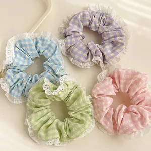 Détail de chouchous à carreaux colorés avec bordure en dentelle blanche pastel