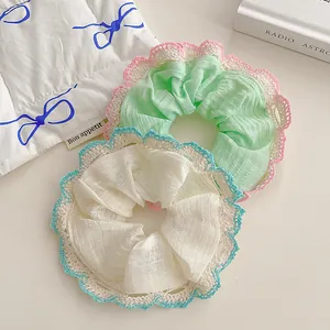 Lace-trimmed ruffle hair scrunchies in pastel green and cream colors for women