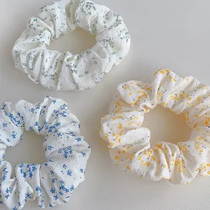 Detailed view of three floral scrunchies in green, blue, and yellow fabric patterns