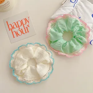 Lace-trimmed scrunchies set in mint green and cream white with delicate scalloped edges