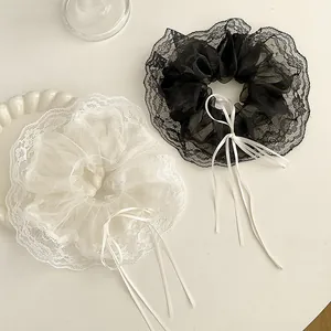 Close-up of black and white lace organza hair scrunchies with long silk ribbons