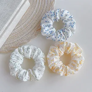 Three-piece floral scrunchies set in blue, green, and yellow for summer ponytails