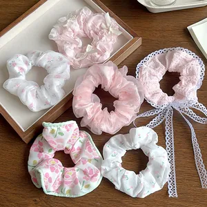 Détails de chouchous à fleurs et dentelle dans des tons rose pastel et blanc