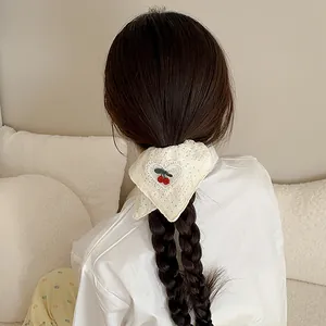 Chouchou en tissu blanc avec broderie cerise et détails en dentelle ajourée de foulard