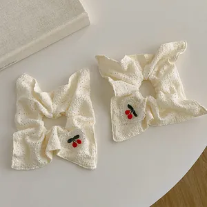 Deux chouchous en dentelle crème avec broderies de cerises rouges et patchs cœur doux