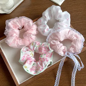 Gros plan détaillé de chouchous en dentelle rose pastel et motifs floraux sur un plateau