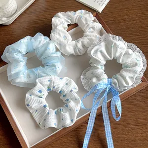 Détail de l'ensemble de 4 chouchous avec dentelle bleue, ruban et motifs floraux