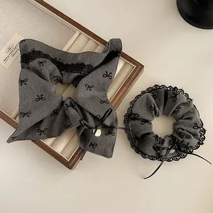 Detail von grauem Haargummi und Stirnband-Set mit schwarzer Spitze und Schleifen