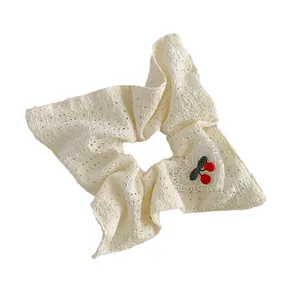 Chouchou en dentelle blanche avec broderie cerise et écusson cœur au style épuré