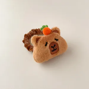 Détail d'un chouchou en peluche capybara avec petite carotte et texture douce marron