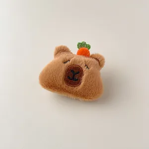 Vue détaillée d'une pince à cheveux ours en peluche marron avec motif carotte
