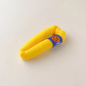 Detailed macro view of a lemon yellow knitted hair clip with a blue smiley face label