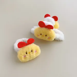 Detailed close-up of plush yellow chick hair clips with red bows and soft fuzzy texture
