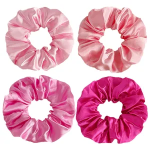 Set of 4 pink satin silk hair scrunchies in gradient shades on a white background