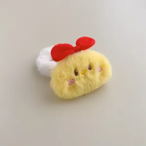 Close-up of a cute yellow plush chicken hair tie with a red bow and detailed embroidery