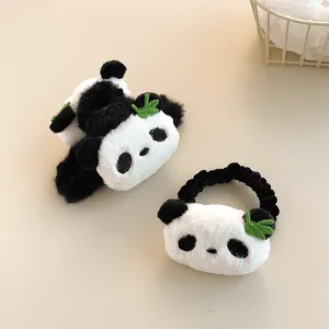 Close-up of cute panda plush hair claw and scrunchie set with green leaf details