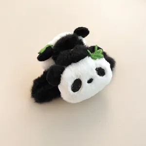 Detail of plush panda hair claw clip with green leaf accents and soft faux fur texture