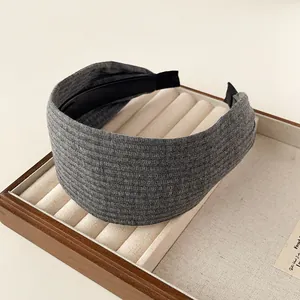 Detailaufnahme eines breiten grauen Strickstirnbandes mit Rippenstruktur auf einem Tablett