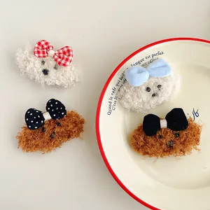 Dettaglio delle mollette in peluche a forma di cane teddy con vari fiocchi colorati