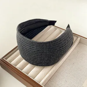 Nahaufnahme des dunkelgrauen Strick-Stirnbands auf Tablett mit gerippter Textur