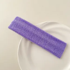 Close-up of purple terry cloth sports headband with soft texture on a white tray