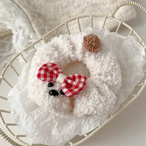 Detalle de coletero de peluche blanco tipo caniche con lazo de cuadros rojos y blancos