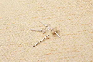 Macro detail of four S925 sterling silver DIY earring posts with cup and cross pin settings